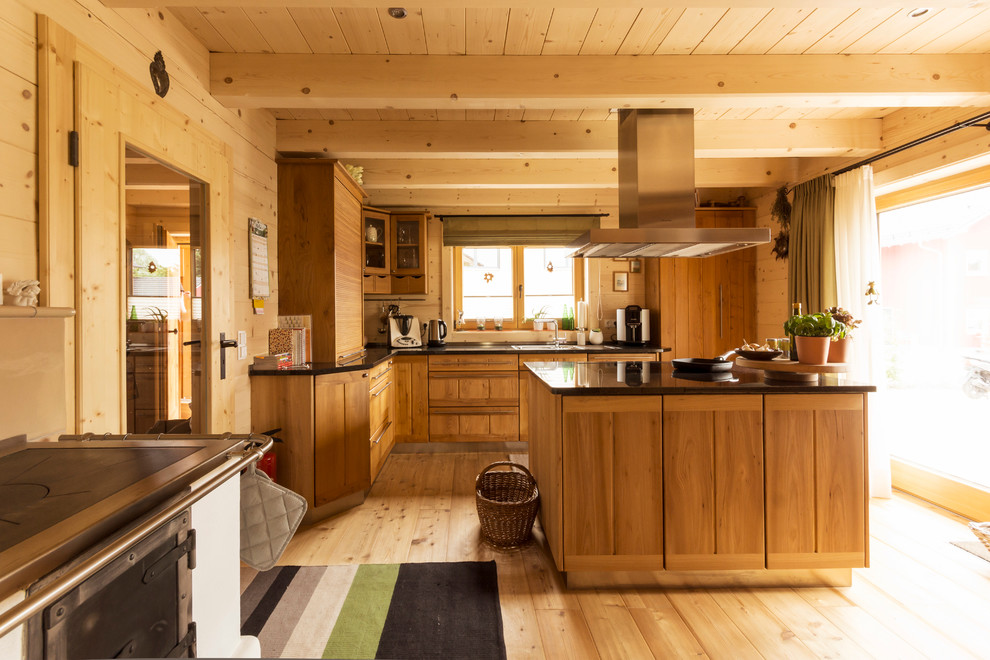 Cette photo montre une grande cuisine encastrable nature en bois brun et L fermée avec un sol en bois brun, îlot, un évier posé et une crédence marron.