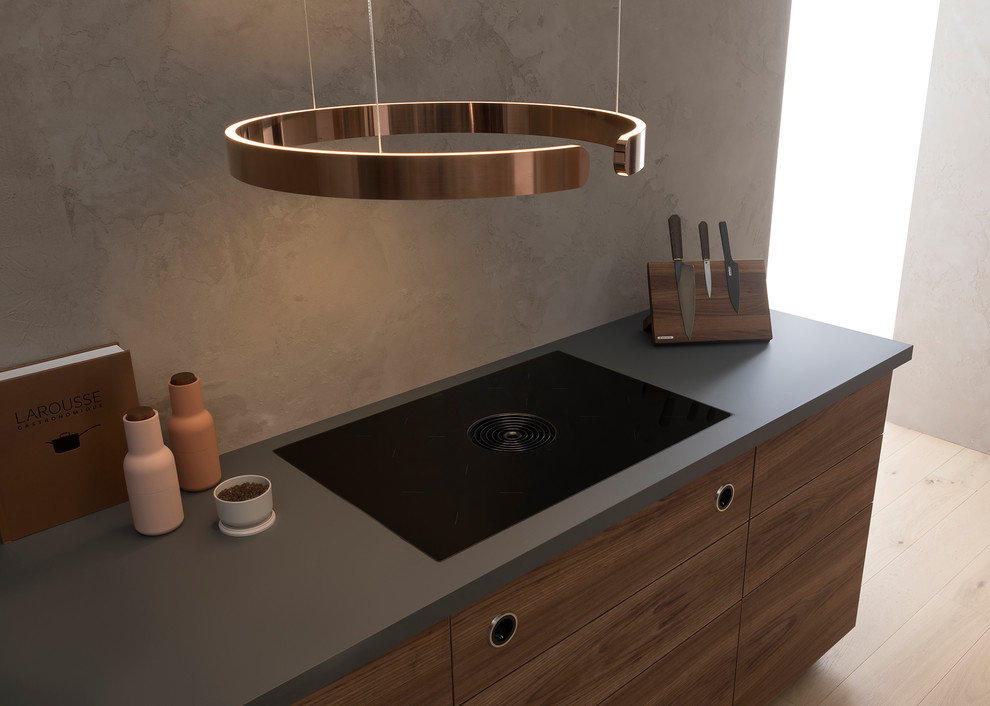 Design ideas for a large contemporary single-wall open plan kitchen in Stuttgart with an integrated sink, flat-panel cabinets, dark wood cabinets, grey splashback, black appliances, a breakfast bar, brown floors and grey worktops.