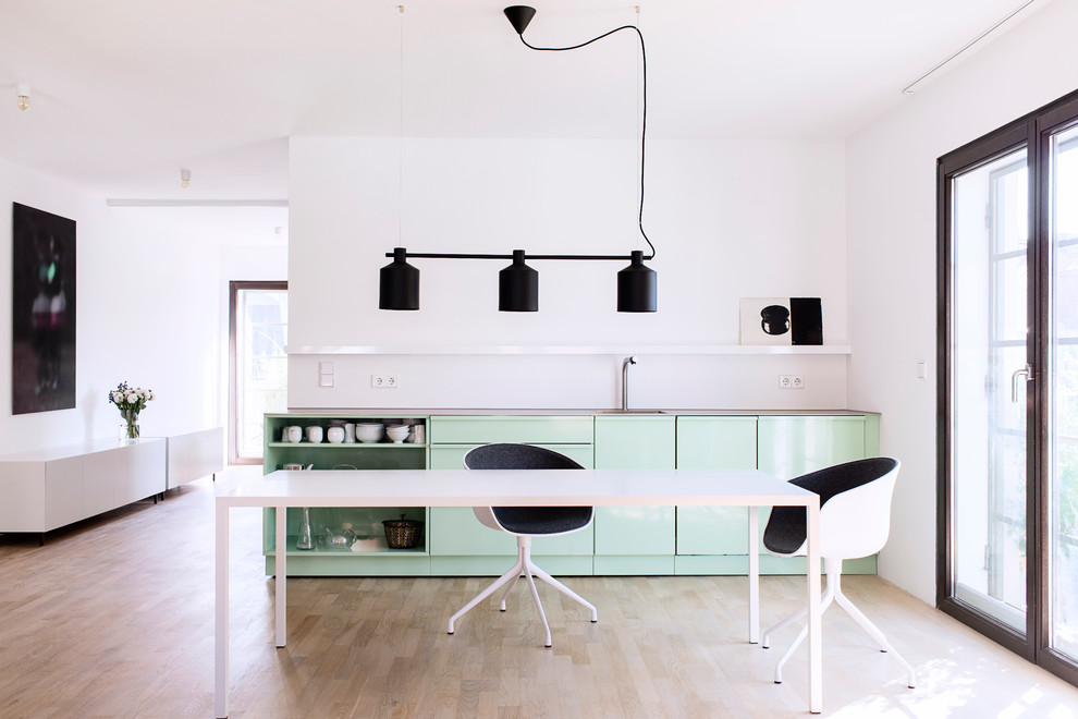 Ispirazione per una cucina design di medie dimensioni con parquet chiaro