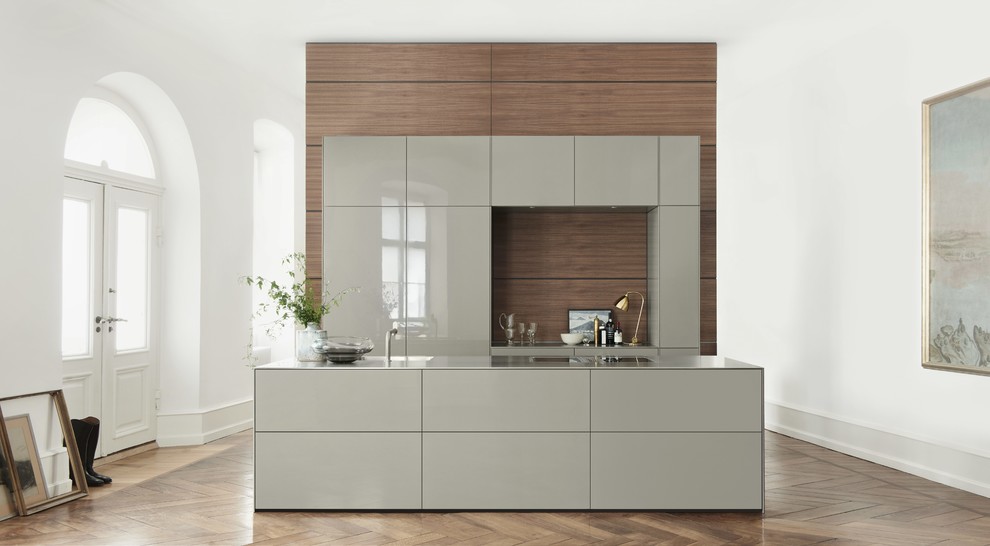 Idée de décoration pour une grande cuisine ouverte linéaire design avec un placard à porte plane, un plan de travail en inox, îlot, une crédence marron, parquet foncé et des portes de placard grises.