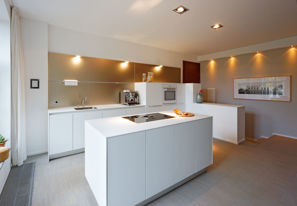 Medium sized contemporary galley open plan kitchen in Dusseldorf with flat-panel cabinets, white cabinets, laminate countertops, beige splashback, an island, a submerged sink and light hardwood flooring.