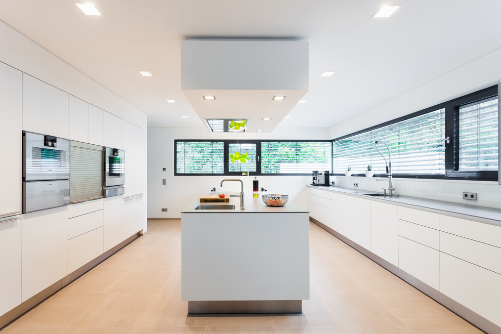 Foto de cocinas en U rectangular moderno grande cerrado con armarios con paneles lisos, puertas de armario blancas, una isla, salpicadero blanco y salpicadero de vidrio templado