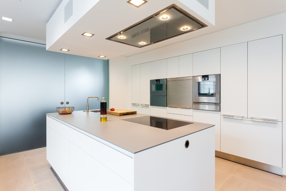 Offene, Einzeilige Moderne Küche mit weißen Schränken, Küchenrückwand in Weiß, Küchengeräten aus Edelstahl und Kücheninsel in Frankfurt am Main