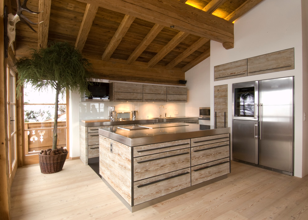 Photo of a rustic l-shaped open plan kitchen in Other with flat-panel cabinets, glass sheet splashback, stainless steel appliances, light hardwood flooring, an island, brown cabinets and stainless steel worktops.