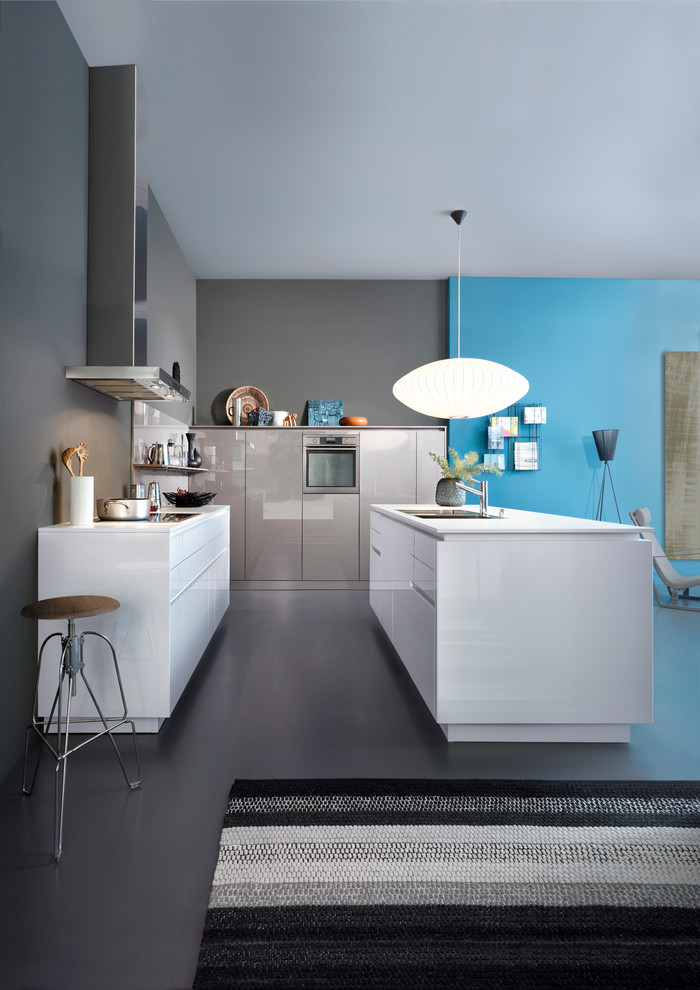 Foto på ett mellanstort funkis kök med öppen planlösning, med en nedsänkt diskho, släta luckor, grå skåp, integrerade vitvaror och en köksö