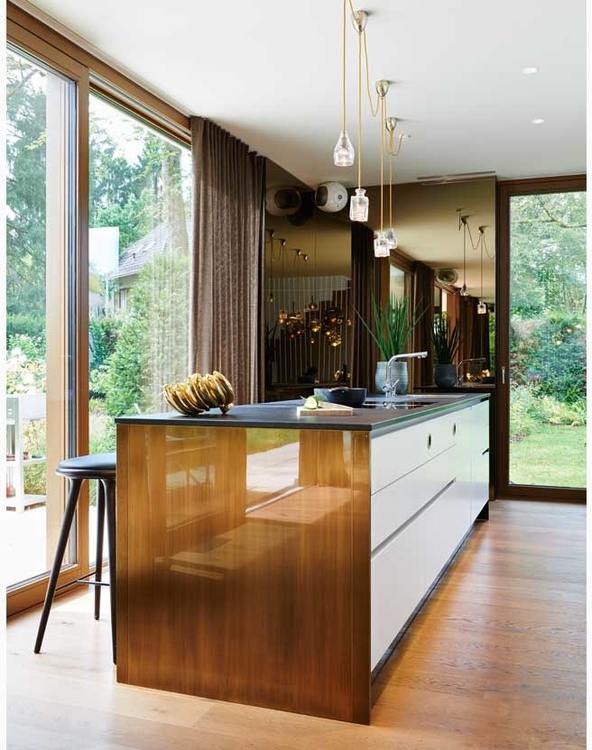 Offene, Mittelgroße Stilmix Küche mit flächenbündigen Schrankfronten, weißen Schränken, braunem Holzboden, Kücheninsel und braunem Boden in München