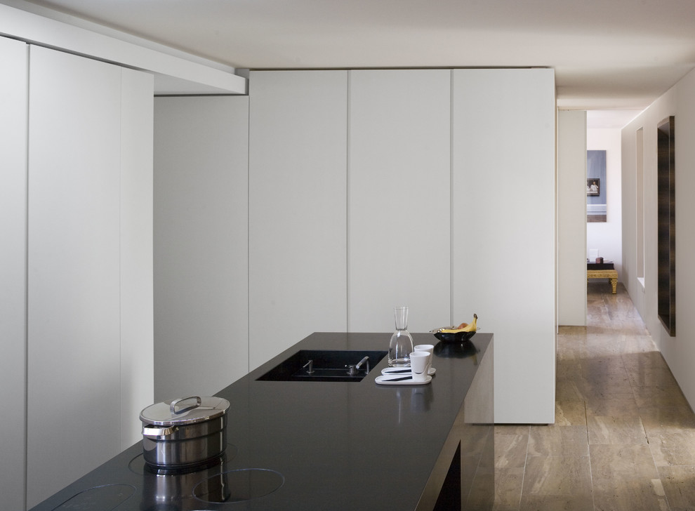 Idées déco pour une cuisine contemporaine de taille moyenne avec un placard à porte plane, des portes de placard blanches et îlot.
