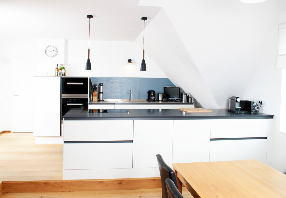 Idee per una cucina minimalista di medie dimensioni con lavello a vasca singola, ante lisce, ante bianche, top in acciaio inossidabile e elettrodomestici in acciaio inossidabile