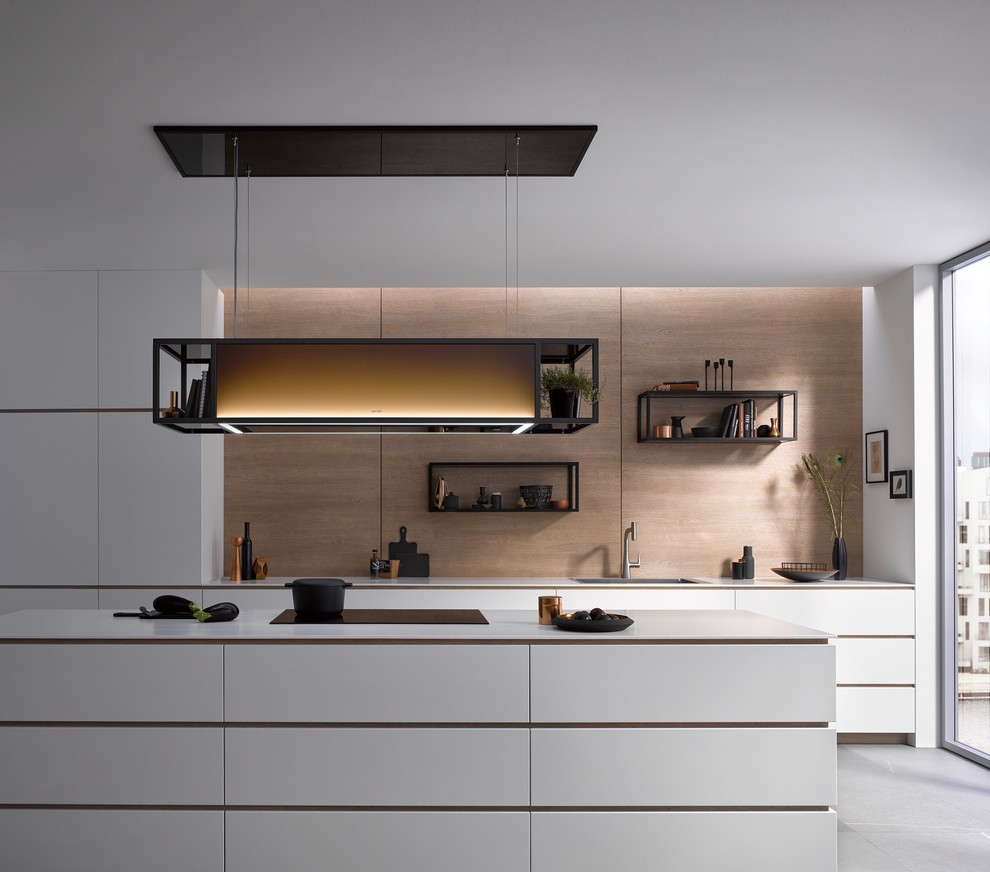 Immagine di una cucina design di medie dimensioni con lavello integrato, ante lisce, ante bianche, paraspruzzi marrone, paraspruzzi in legno, elettrodomestici neri e top bianco