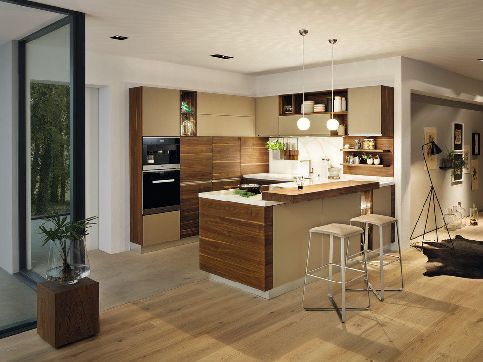 Réalisation d'une grande cuisine ouverte design en U et bois brun avec un placard à porte plane, une péninsule, parquet clair et un sol beige.