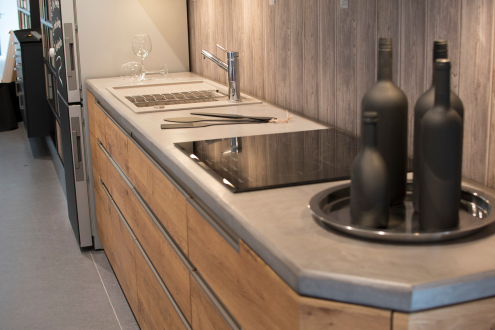 ニュルンベルクにある高級な中くらいなコンテンポラリースタイルのおしゃれなキッチン (シングルシンク、フラットパネル扉のキャビネット、中間色木目調キャビネット、コンクリートカウンター、グレーのキッチンパネル、クッションフロア、アイランドなし、グレーの床) の写真