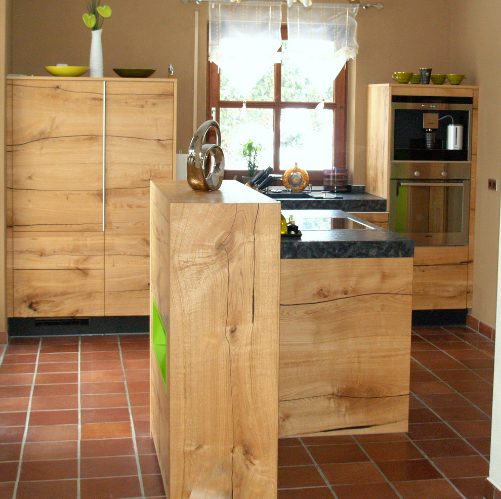Bild på ett avskilt, mellanstort rustikt linjärt kök, med en enkel diskho, släta luckor, skåp i mellenmörkt trä, beige stänkskydd, rostfria vitvaror, klinkergolv i keramik, en köksö, orange golv och granitbänkskiva