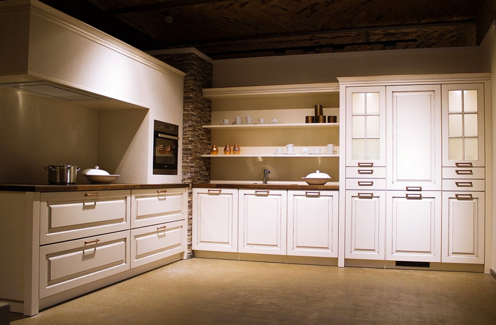 Diseño de cocina campestre con armarios con rebordes decorativos y puertas de armario blancas