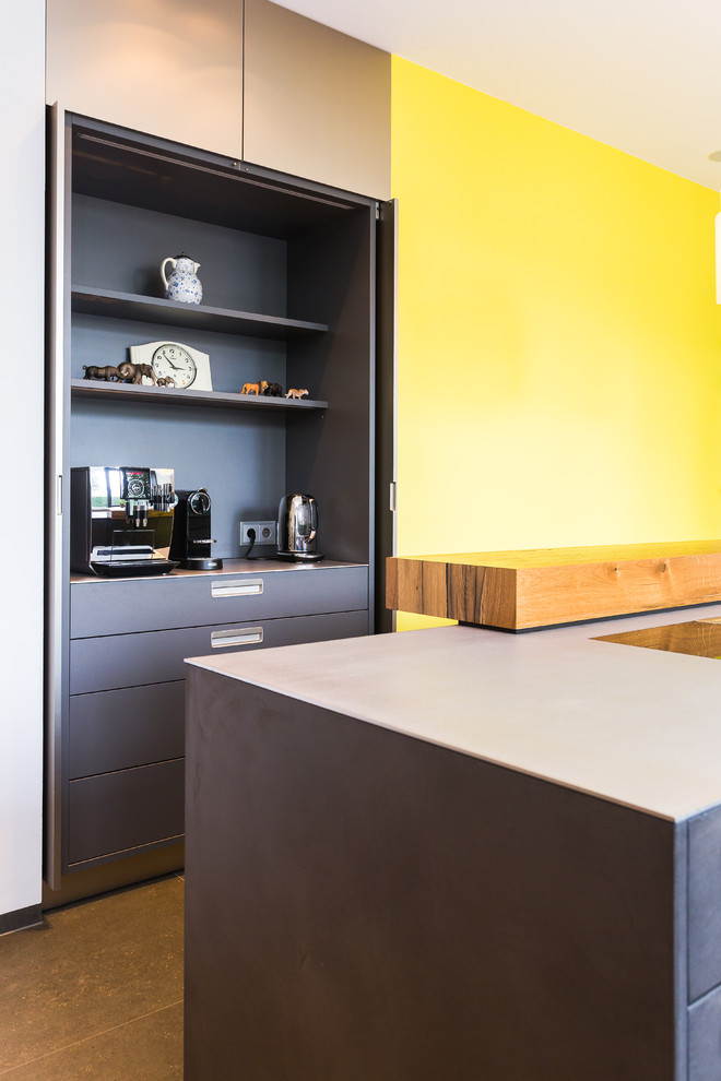 Small modern galley kitchen pantry in Frankfurt with flat-panel cabinets, stainless steel cabinets, stainless steel worktops, yellow splashback and grey worktops.