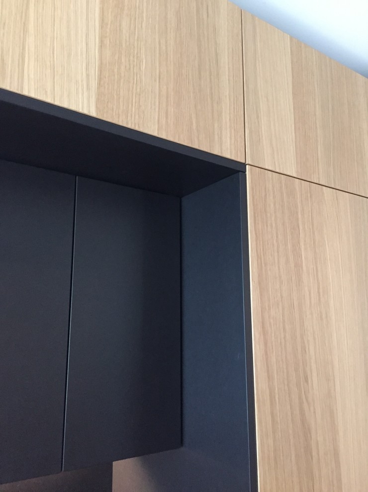 Inspiration pour une cuisine ouverte parallèle design en bois brun de taille moyenne avec un placard à porte plane, un plan de travail en granite, une crédence noire et îlot.