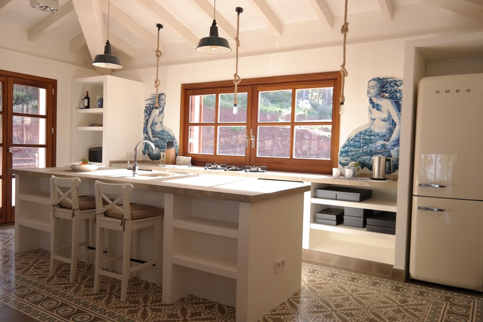Ejemplo de cocina lineal mediterránea abierta con encimera de mármol, salpicadero de azulejos de cerámica, suelo de azulejos de cemento y una isla