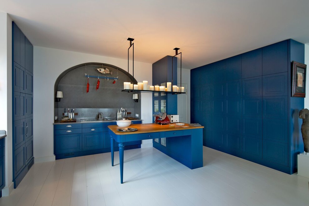 ミュンヘンにあるエクレクティックスタイルのおしゃれなキッチン (シェーカースタイル扉のキャビネット、青いキャビネット、ステンレスカウンター、メタリックのキッチンパネル、白い床) の写真
