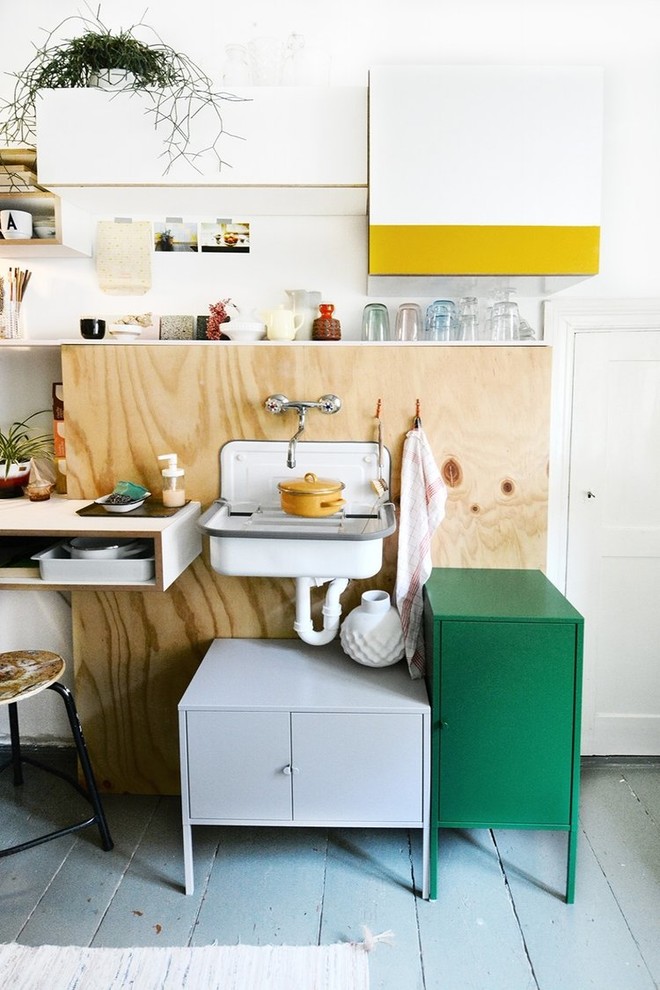 Kleine Eklektische Küche mit Landhausspüle, Rückwand aus Holz, gebeiztem Holzboden und grauem Boden in Berlin