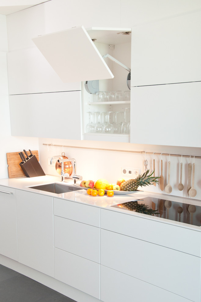 Foto de cocina contemporánea sin isla con puertas de armario blancas, encimera de acrílico, salpicadero blanco y encimeras blancas