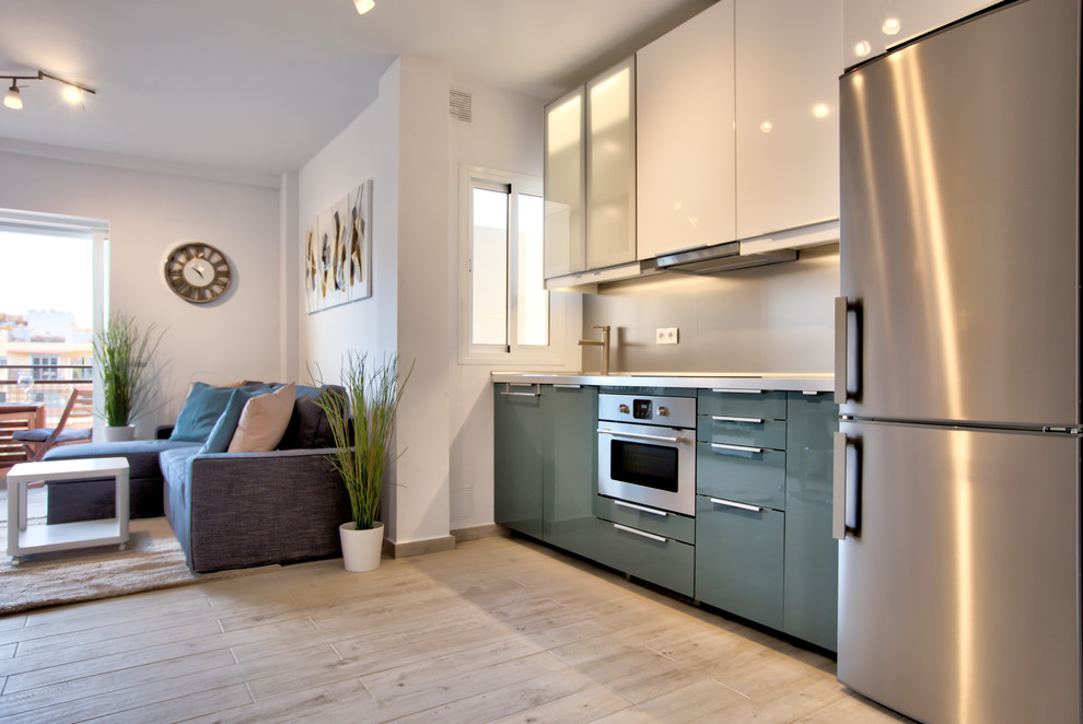 Inspiration for a small contemporary single-wall open plan kitchen in Dusseldorf with a single-bowl sink, turquoise cabinets, wood worktops, metallic splashback, stainless steel appliances, ceramic flooring, no island and beige floors.