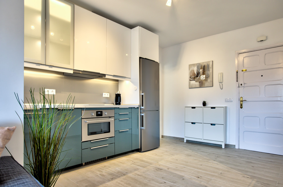 Small trendy single-wall ceramic tile and beige floor open concept kitchen photo in Dusseldorf with a single-bowl sink, turquoise cabinets, wood countertops, metallic backsplash, stainless steel appliances and no island