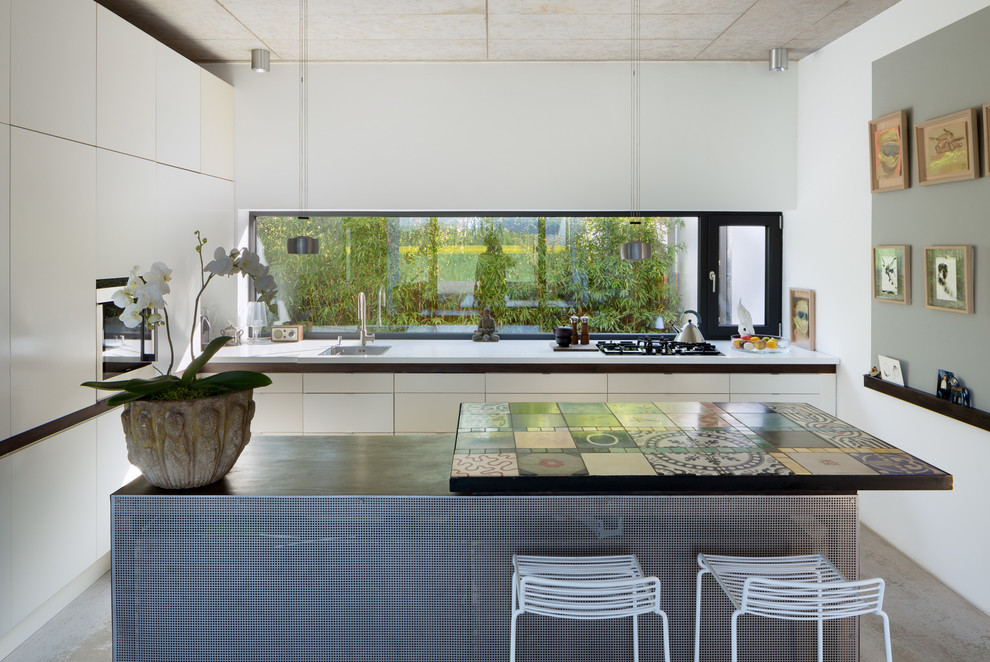 Large modern l-shaped enclosed kitchen in Cologne with a built-in sink, flat-panel cabinets, white cabinets, integrated appliances and an island.