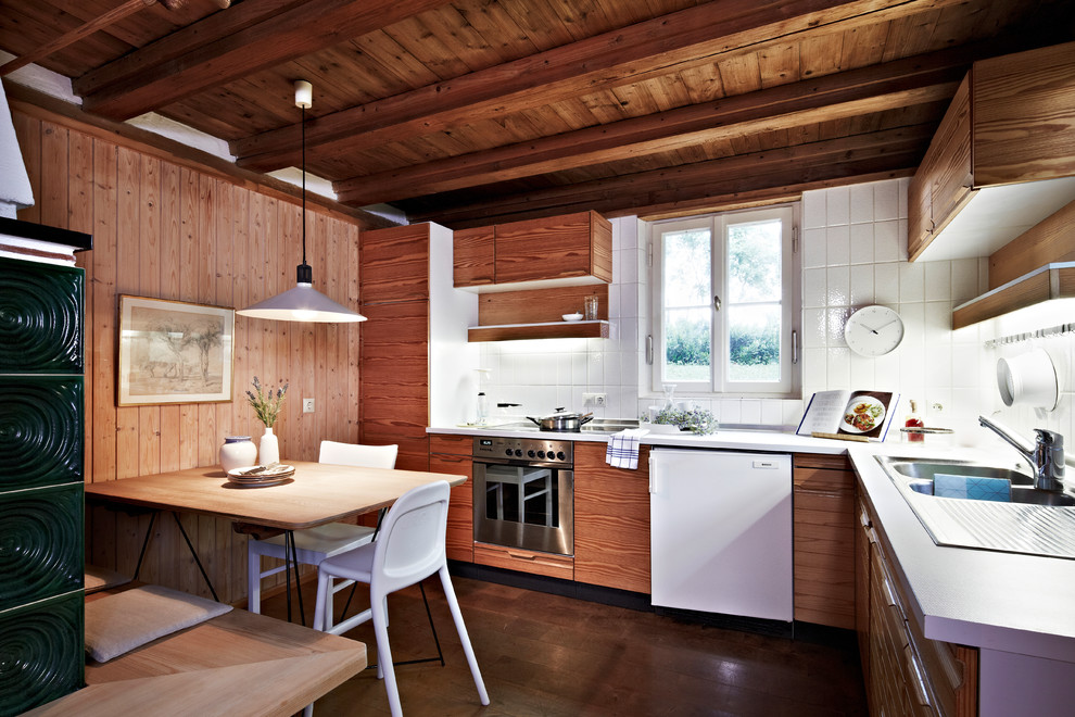 Inspiration for a mid-sized rustic l-shaped dark wood floor and brown floor eat-in kitchen remodel in Nuremberg with a double-bowl sink, flat-panel cabinets, medium tone wood cabinets, white backsplash, stainless steel appliances, white countertops, ceramic backsplash and no island