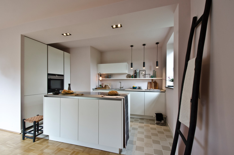 Bild på ett litet funkis kök, med vita skåp, kaklad bänkskiva, rosa stänkskydd, cementgolv, en köksö, en undermonterad diskho och släta luckor
