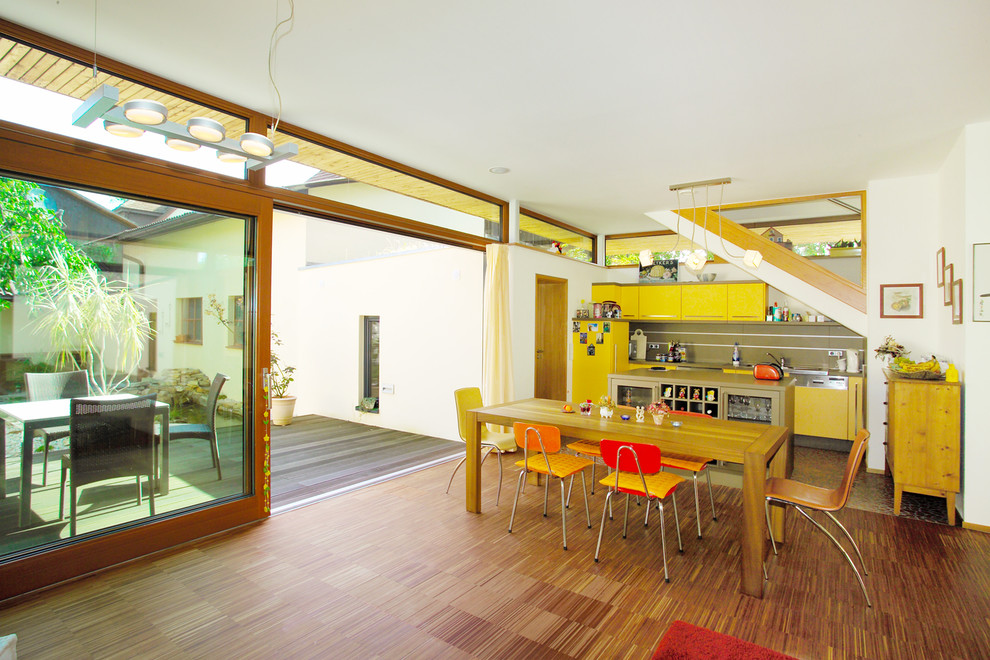 Mittelgroße, Offene, Einzeilige Moderne Küche mit gelben Schränken, Küchenrückwand in Grau, Küchengeräten aus Edelstahl und Kücheninsel in Nürnberg