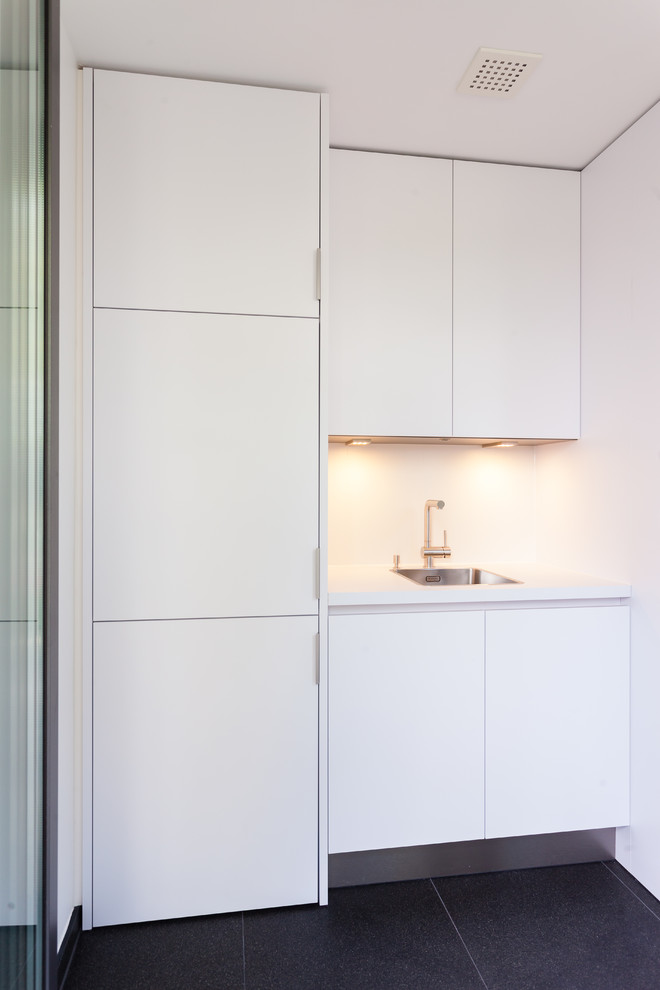 Einzeilige, Kleine Moderne grifflose Küche mit Einbauwaschbecken, flächenbündigen Schrankfronten, weißen Schränken und Küchenrückwand in Weiß in Frankfurt am Main