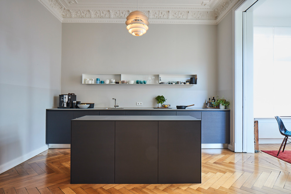 Idéer för ett stort modernt grå linjärt kök med öppen planlösning, med en nedsänkt diskho, släta luckor, grå skåp, träbänkskiva, grått stänkskydd, målat trägolv, en köksö och brunt golv