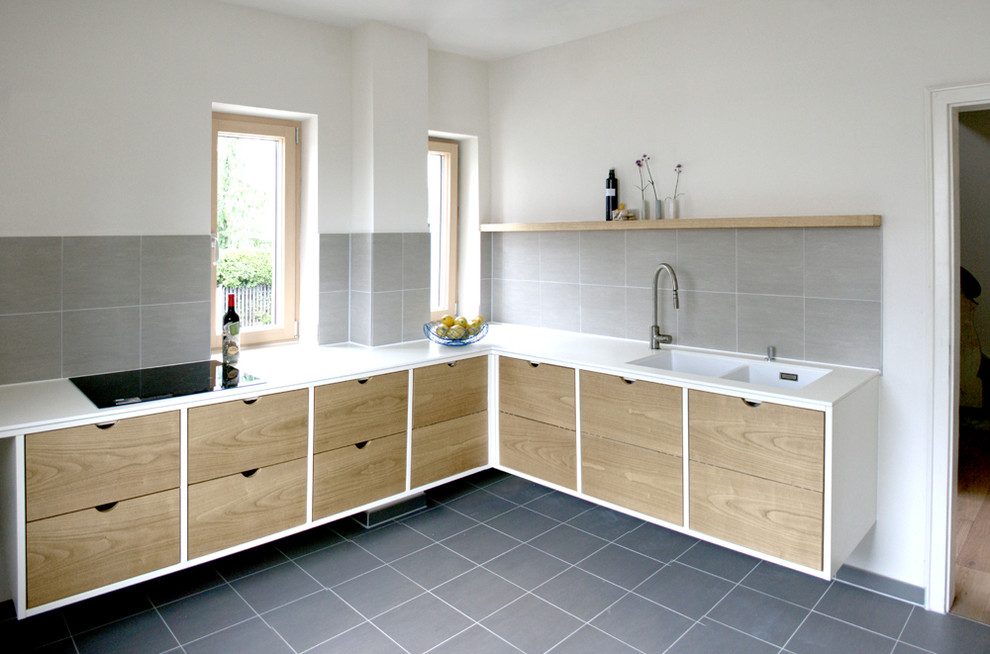 Design ideas for a contemporary l-shaped enclosed kitchen in Munich with an integrated sink, flat-panel cabinets, light wood cabinets, grey splashback and no island.