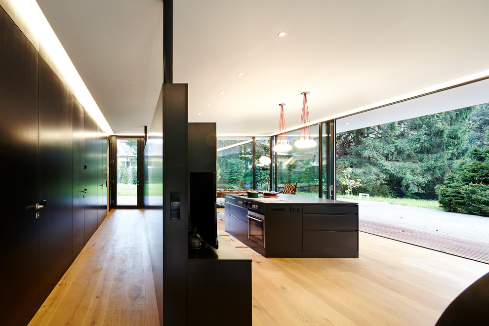 Example of a minimalist medium tone wood floor and brown floor kitchen design in Other