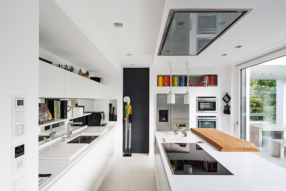 Immagine di una grande cucina contemporanea con lavello sottopiano, ante lisce e elettrodomestici in acciaio inossidabile