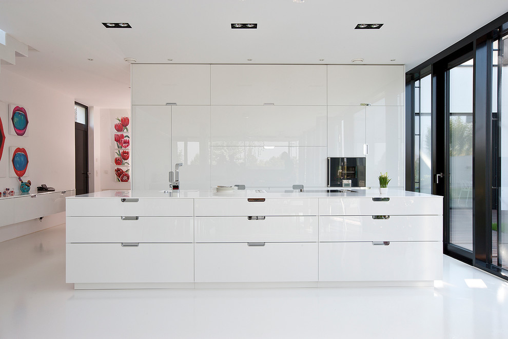 Exempel på ett stort modernt kök med öppen planlösning, med en enkel diskho, släta luckor, vita skåp, integrerade vitvaror, en köksö, vitt stänkskydd och linoleumgolv