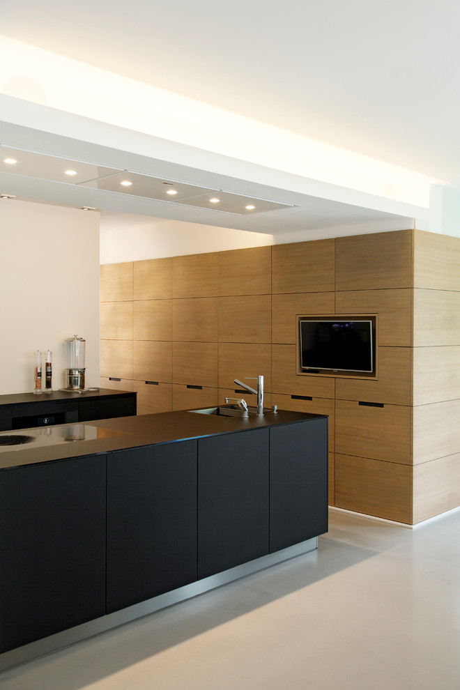 Exemple d'une cuisine ouverte moderne en bois clair de taille moyenne avec un évier 1 bac, un placard à porte plane et îlot.