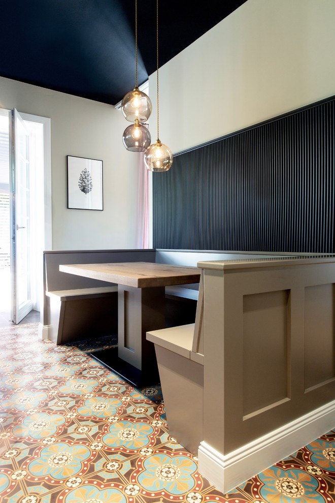 Inredning av ett klassiskt mellanstort kök, med luckor med profilerade fronter, beige skåp, cementgolv och flerfärgat golv