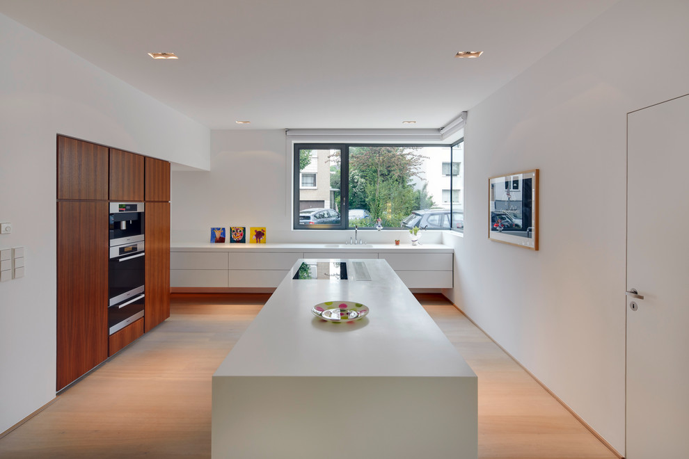 Источник вдохновения для домашнего уюта: большая отдельная кухня в стиле модернизм с плоскими фасадами, белыми фасадами, светлым паркетным полом, островом, двойной мойкой и техникой из нержавеющей стали