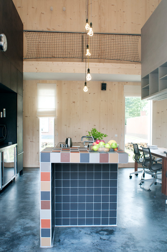 他の地域にある広いコンテンポラリースタイルのおしゃれなキッチン (フラットパネル扉のキャビネット、黒いキャビネット) の写真