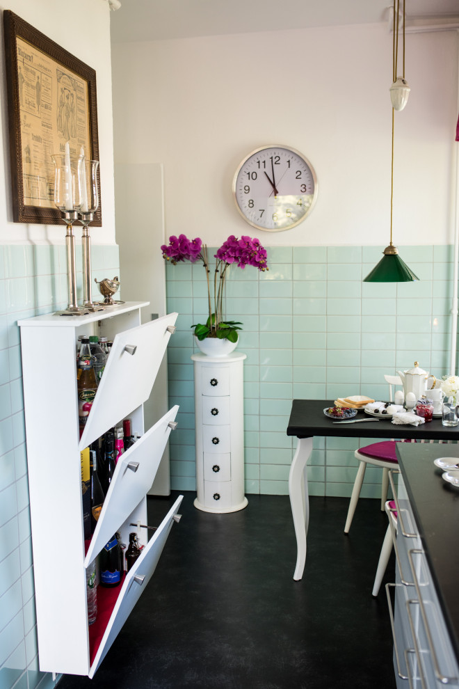 Foto di una cucina parallela eclettica chiusa e di medie dimensioni con lavello da incasso, ante bianche, top in legno, paraspruzzi verde, paraspruzzi con piastrelle di vetro, elettrodomestici in acciaio inossidabile, pavimento in linoleum, pavimento nero e top nero