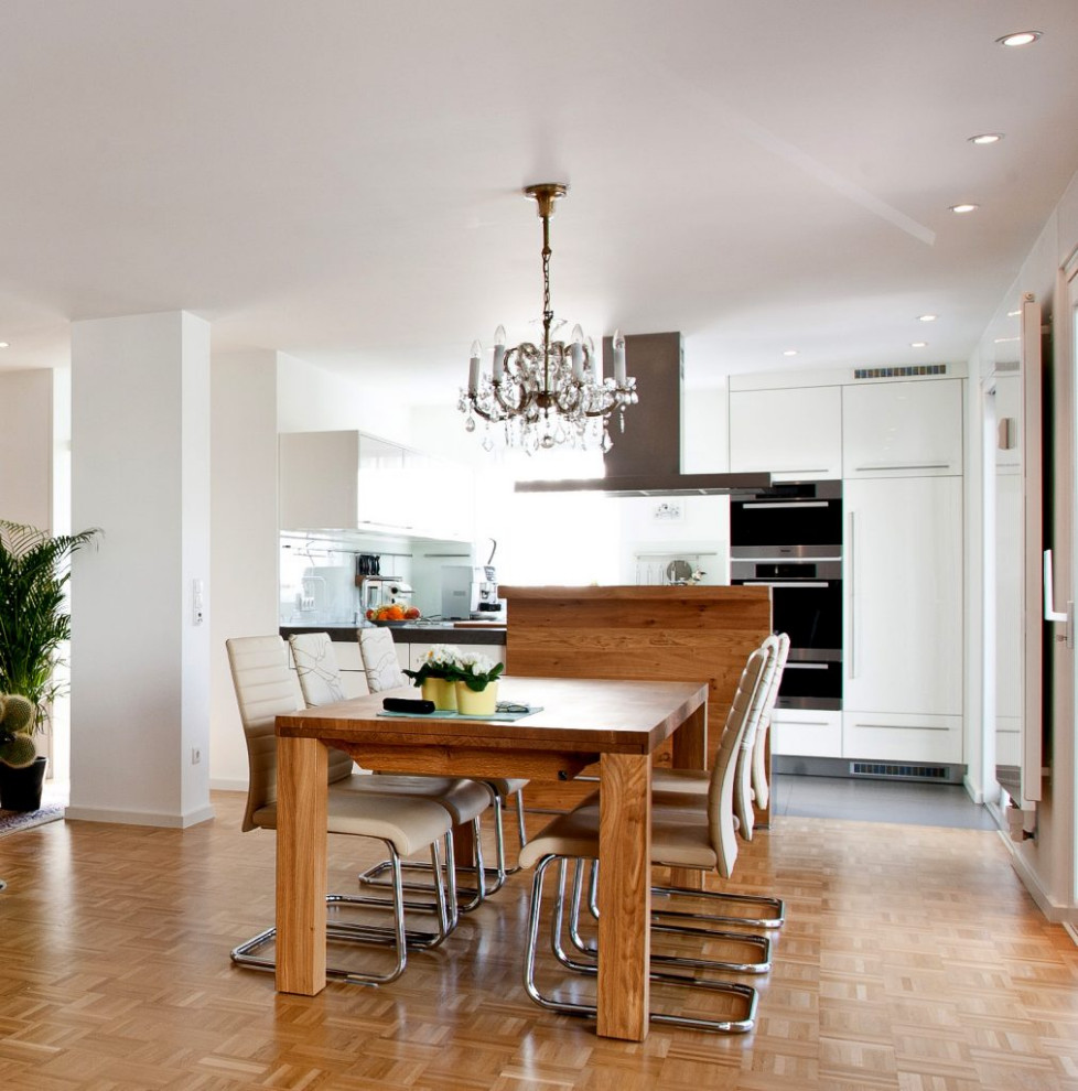 Rustik inredning av ett mellanstort kök, med en integrerad diskho, luckor med profilerade fronter, vita skåp, marmorbänkskiva, vitt stänkskydd och svarta vitvaror