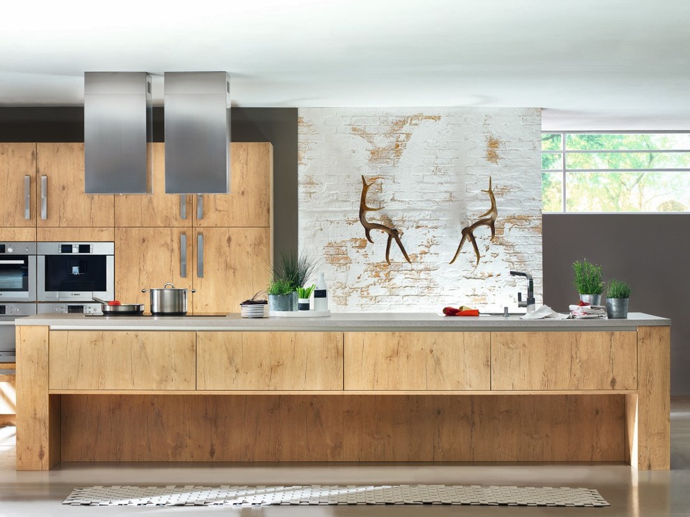 Immagine di una cucina minimal di medie dimensioni con lavello da incasso, top in cemento e elettrodomestici in acciaio inossidabile