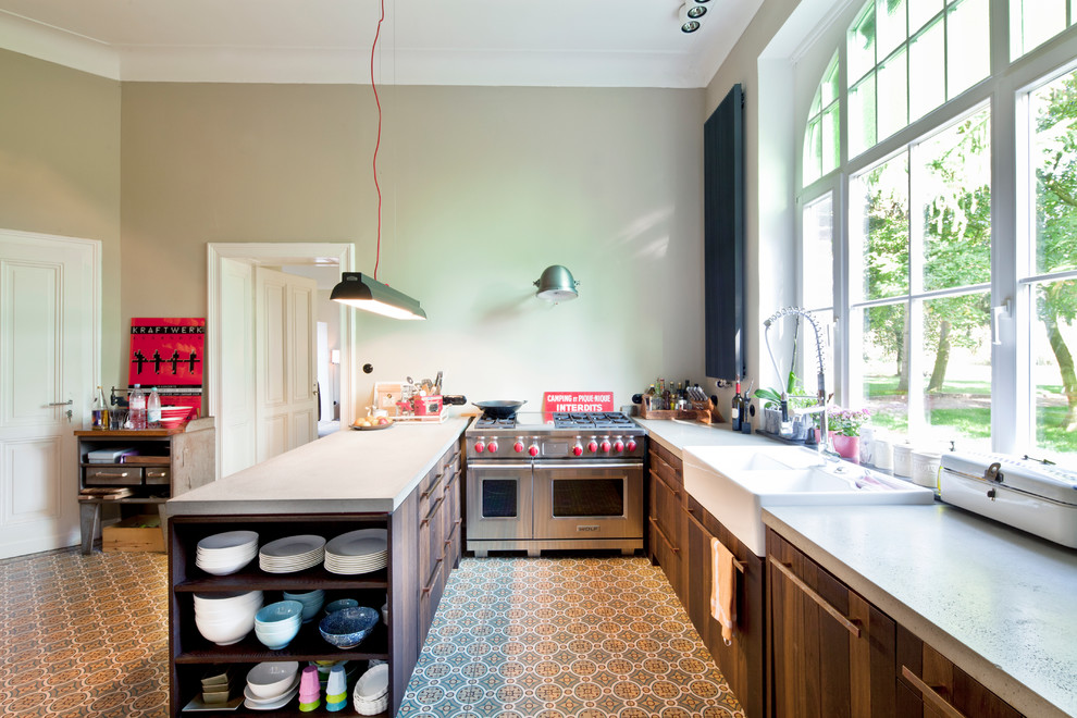 ドルトムントにある広いインダストリアルスタイルのおしゃれなキッチン (ダブルシンク、フラットパネル扉のキャビネット、濃色木目調キャビネット、グレーのキッチンパネル、シルバーの調理設備) の写真