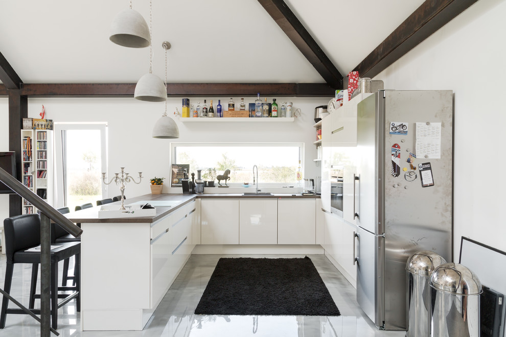 Esempio di una cucina contemporanea di medie dimensioni con ante lisce, ante bianche, top in legno e elettrodomestici neri