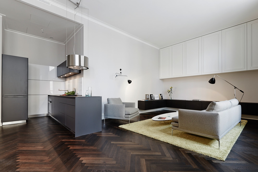 Example of a small trendy single-wall medium tone wood floor and brown floor open concept kitchen design in Berlin with an integrated sink, flat-panel cabinets, solid surface countertops, white backsplash and no island