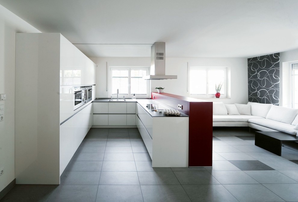 Design ideas for a large contemporary u-shaped kitchen/diner in Munich with an integrated sink, flat-panel cabinets, white cabinets, white splashback, stainless steel appliances, cement flooring, a breakfast bar and grey floors.