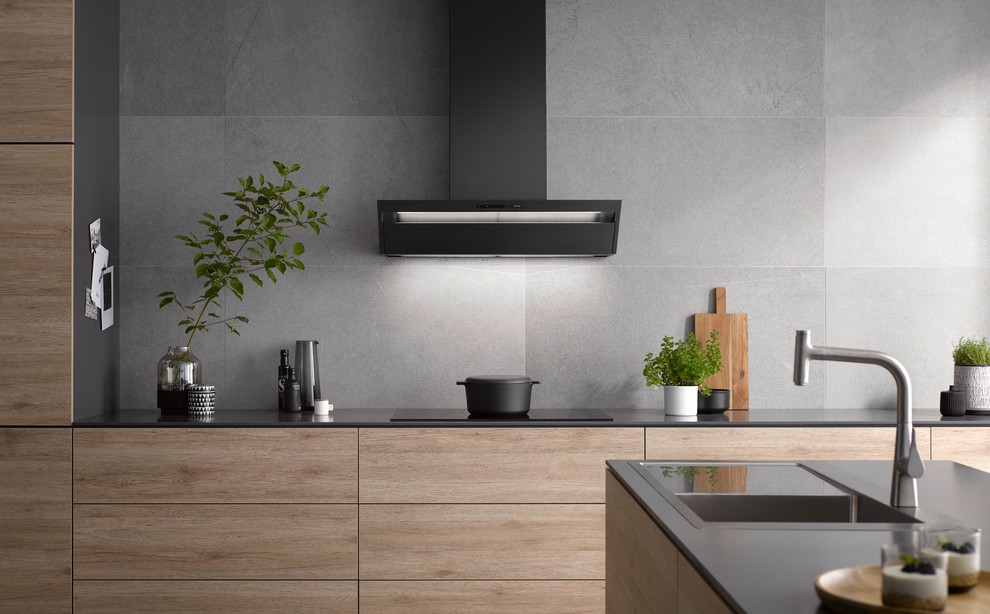 Foto di una grande cucina design con lavello integrato, ante lisce, ante in legno scuro, paraspruzzi grigio, elettrodomestici neri e top nero