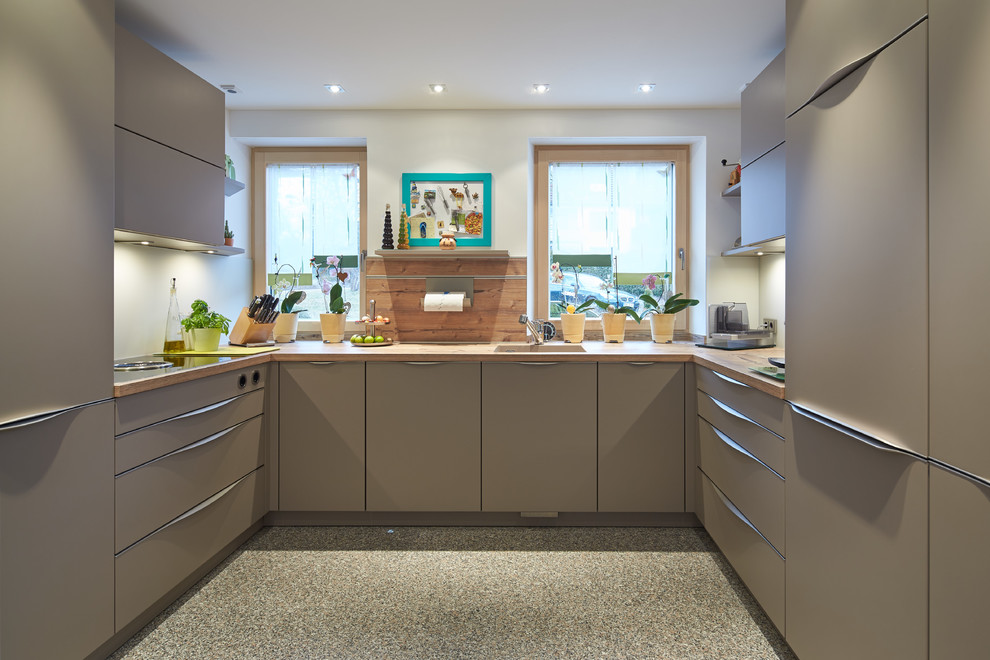 Mittelgroße Moderne Küche mit Unterbauwaschbecken, flächenbündigen Schrankfronten, grauen Schränken, Küchenrückwand in Weiß, buntem Boden und Arbeitsplatte aus Holz in München