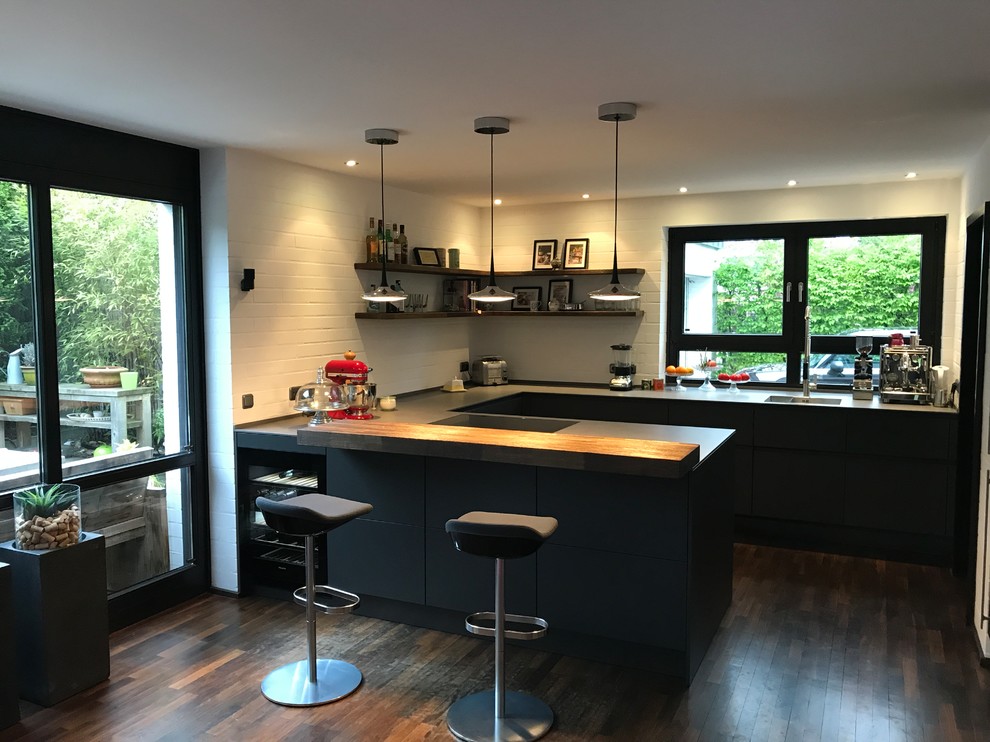 Eat-in kitchen - large industrial u-shaped dark wood floor eat-in kitchen idea in Other with an integrated sink, flat-panel cabinets, gray cabinets, quartz countertops, white backsplash, brick backsplash, stainless steel appliances, a peninsula and yellow countertops