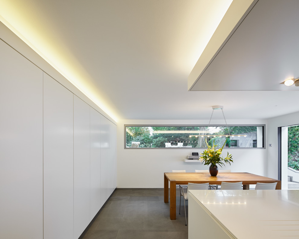 Photo of a large contemporary kitchen/diner in Cologne with flat-panel cabinets and white cabinets.